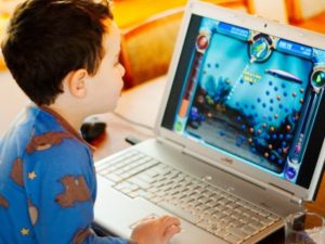 kid playing game on laptop